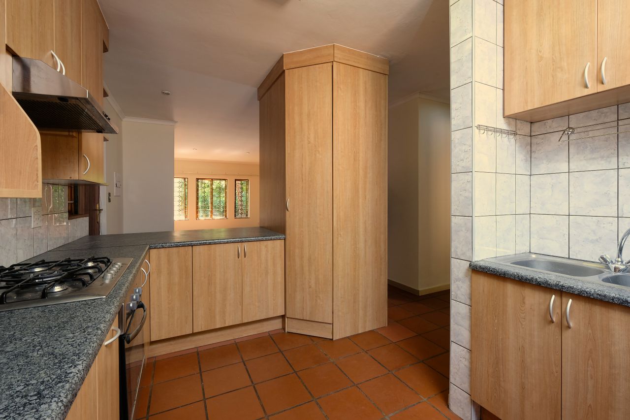 Spacious and modern kitchen featuring wooden cabinetry and natural light streaming through windows.